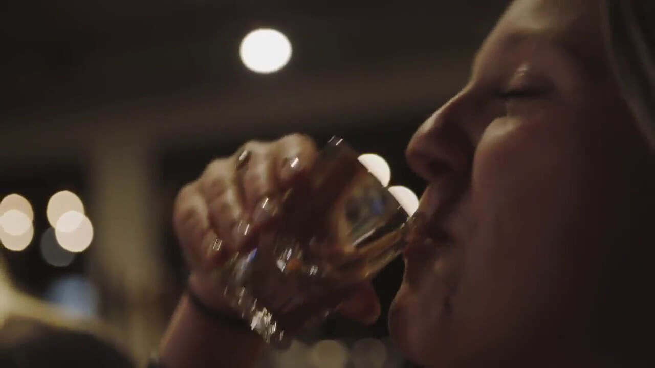 women drinking from a short glass