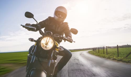 Motorcyclist on bending Asheville road with light on motorcycle