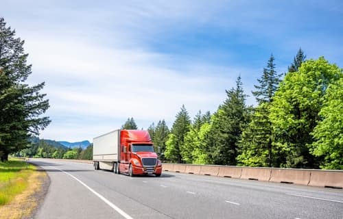 Truck on Road with Green Trees in Background