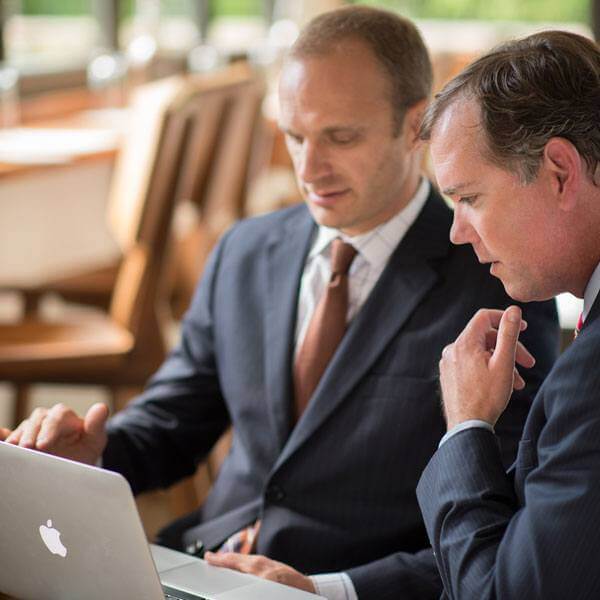 Lakota Denton in background with client in foreground looking at Apple computer